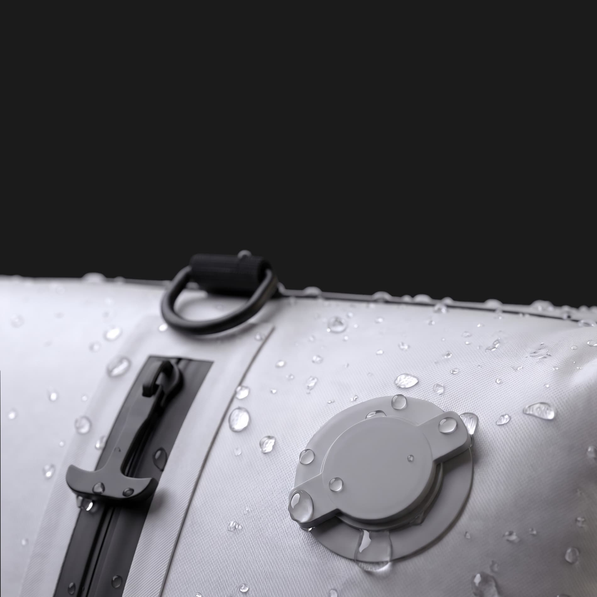Gros plan du sac singope imperméable : fermeture éclair étanche, valve anti-retour et gouttes d'eau sur le nylon